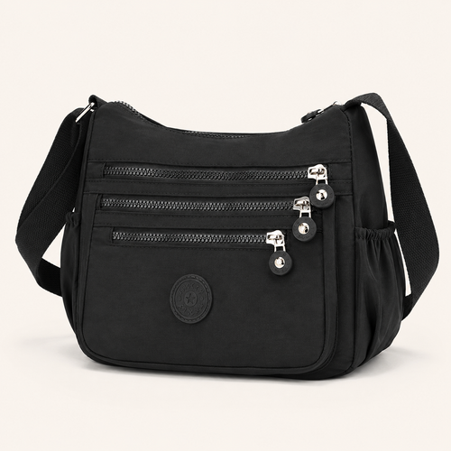 Willa London Everyday Organiser Crossbody Bag in Black, front three-quarter view showing three horizontal zips and silver-tone hardware